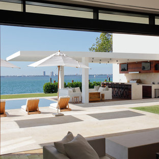 Ispirazione per un grande patio o portico moderno dietro casa con un tetto a sbalzo e piastrelle