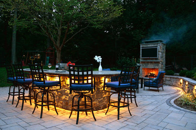 Inspiration for a mid-sized modern backyard concrete paver patio remodel in Other with a fireplace