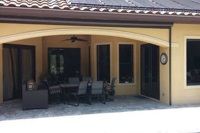 Inspiration for a medium sized classic back patio in Orange County with natural stone paving and a roof extension.