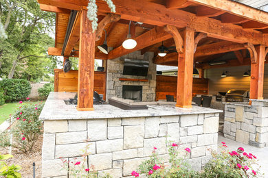 Ejemplo de patio de estilo americano grande en patio trasero con cocina exterior, losas de hormigón y pérgola