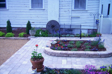 Ejemplo de patio de tamaño medio sin cubierta en patio trasero con jardín de macetas y adoquines de ladrillo