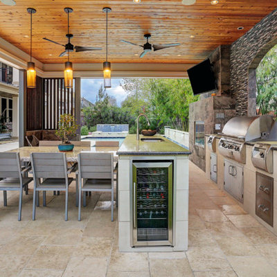 Huge trendy backyard tile patio kitchen photo in Houston with a gazebo
