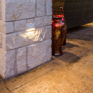 Idee per un patio o portico tradizionale di medie dimensioni e dietro casa con un focolare, cemento stampato e un tetto a sbalzo