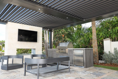 Example of a small backyard patio kitchen design in Tampa with a pergola