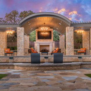 Ispirazione per un grande patio o portico dietro casa con un caminetto, pavimentazioni in pietra naturale e un gazebo o capanno