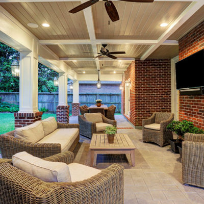 Example of a mid-sized classic backyard stamped concrete patio design in Houston with a roof extension