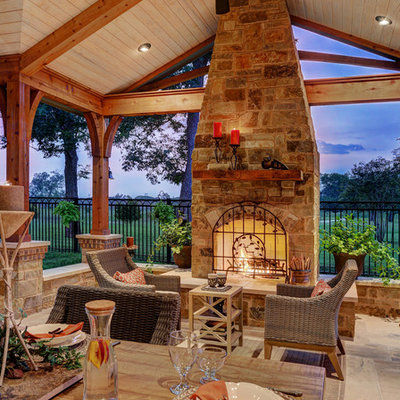 Patio - huge rustic backyard tile patio idea in Houston with a roof extension and a fireplace