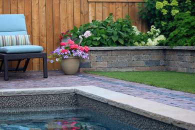 Imagen de patio en patio trasero con fuente y adoquines de hormigón