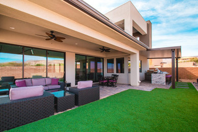 Großer Moderner Patio hinter dem Haus mit Outdoor-Küche, Pflastersteinen und Markisen in Las Vegas