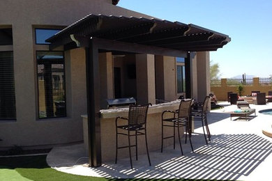 Imagen de patio mediterráneo grande en patio trasero con cocina exterior, losas de hormigón y pérgola