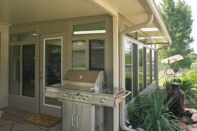 Inspiration for a mid-sized backyard stone patio kitchen remodel in Sacramento with a roof extension