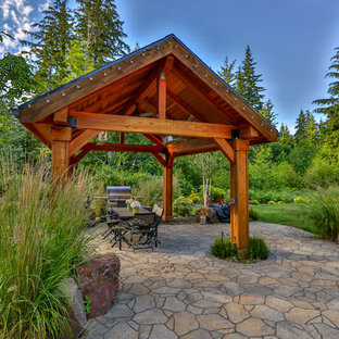 Inspiration for a large craftsman backyard stone patio remodel in Seattle with a gazebo