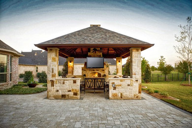 Example of a large mountain style backyard concrete paver patio design in Dallas with a fire pit and a gazebo