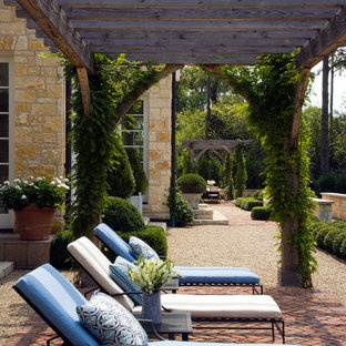 Esempio di un ampio patio o portico classico dietro casa con graniglia di granito e una pergola