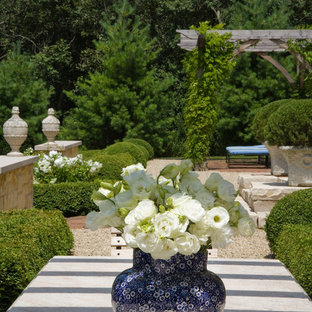 Esempio di un ampio patio o portico tradizionale dietro casa con graniglia di granito e una pergola