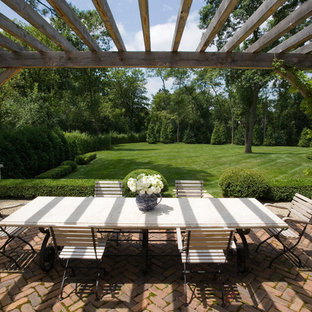 Inspiration pour une très grande terrasse arrière traditionnelle avec un gravier de granite et une pergola.