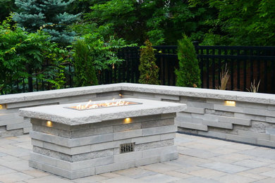 Example of a mid-sized classic backyard concrete paver patio design in Toronto with a fire pit
