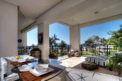 This is an example of a large contemporary back patio in Orange County with tiled flooring and a roof extension.
