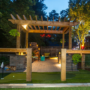 Esempio di un patio o portico tradizionale di medie dimensioni e dietro casa con un focolare, una pergola e pavimentazioni in mattoni