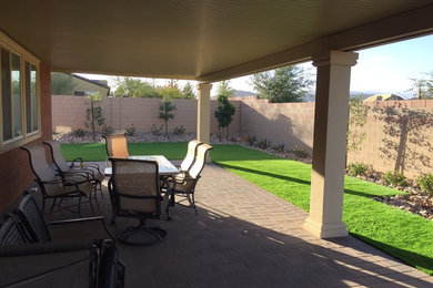 Patio - mid-sized traditional backyard brick patio idea in Las Vegas with a roof extension