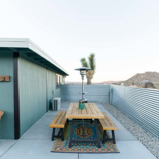 Idee per un grande patio o portico boho chic nel cortile laterale con lastre di cemento e nessuna copertura