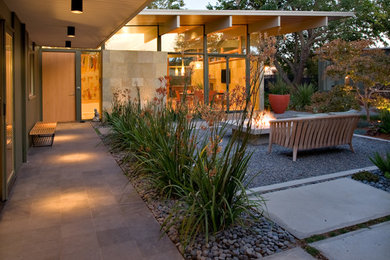 Idee per un patio o portico minimalista in cortile con un focolare, pavimentazioni in cemento e un tetto a sbalzo