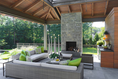 Immagine di un patio o portico chic con una pergola e un caminetto