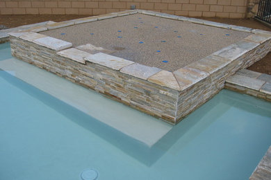 Example of a mid-sized trendy backyard stone patio fountain design in Phoenix with no cover