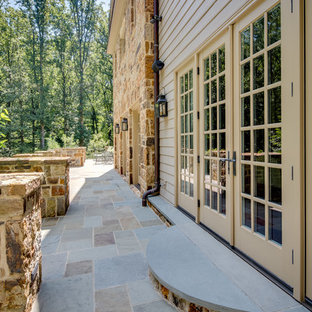 Idee per un ampio patio o portico country dietro casa con pavimentazioni in pietra naturale e nessuna copertura