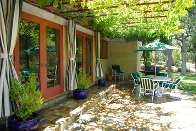 Ejemplo de patio rústico grande en patio trasero y anexo de casas con cocina exterior y adoquines de piedra natural