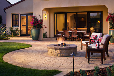 Inspiration for a mid-sized mediterranean backyard concrete paver patio remodel in San Diego with a fire pit and no cover