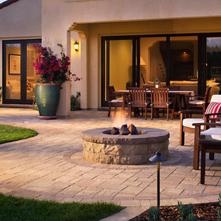 Inspiration for a mid-sized mediterranean backyard concrete paver patio remodel in San Diego with a fire pit and no cover