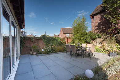 This is an example of a medium sized modern back patio in Other with concrete paving.