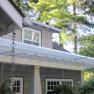 Ispirazione per un patio o portico stile americano di medie dimensioni e dietro casa con pedane e una pergola