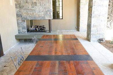 Inspiration for a large rustic back patio in Denver with a fireplace, tiled flooring and a roof extension.