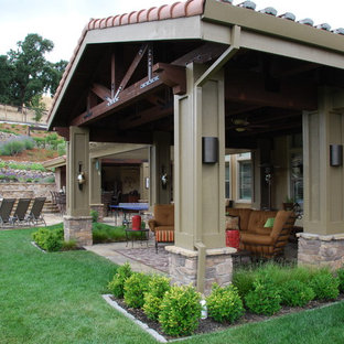Example of a large tuscan backyard stone patio design in San Francisco with a roof extension