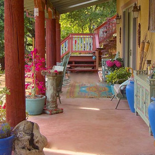 Esempio di un patio o portico etnico di medie dimensioni e dietro casa con fontane, lastre di cemento e un tetto a sbalzo
