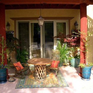 Ispirazione per un patio o portico etnico di medie dimensioni e dietro casa con fontane, lastre di cemento e un tetto a sbalzo
