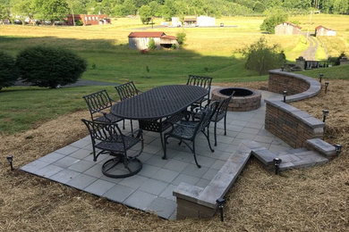 Inspiration for a mid-sized country side yard concrete paver patio remodel in Other with a fire pit