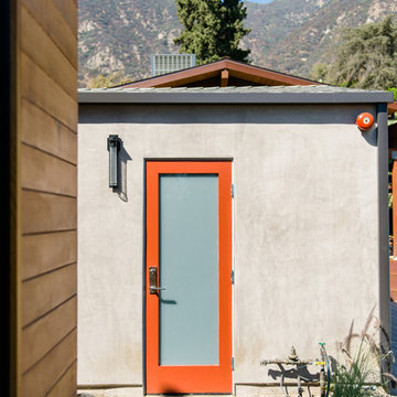 red side door at smooth stucco / modern garage entry door