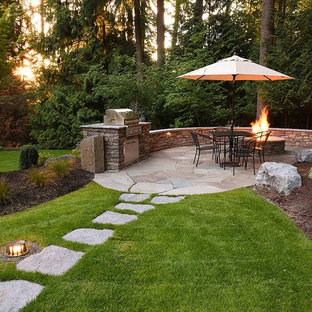 Ispirazione per un grande patio o portico tradizionale dietro casa con un focolare e pavimentazioni in pietra naturale