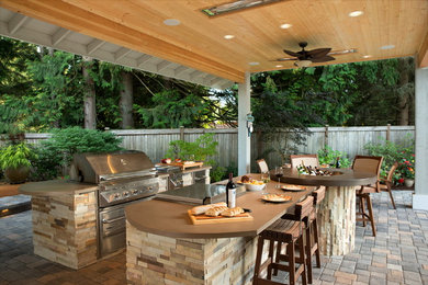 Patio kitchen - large rustic backyard brick patio kitchen idea in Seattle with a roof extension
