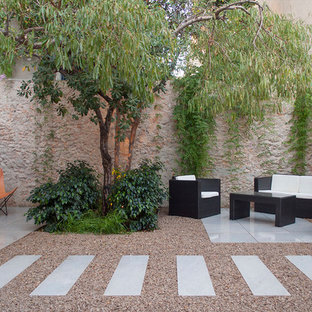 Modelo de patio contemporáneo, en patio trasero, con suelo de baldosas