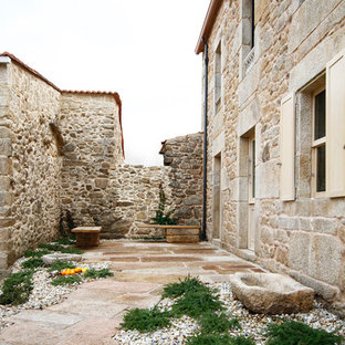 Idee per un patio o portico mediterraneo di medie dimensioni e nel cortile laterale con pavimentazioni in pietra naturale e nessuna copertura