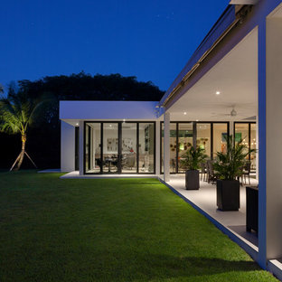 This is an example of an expansive midcentury courtyard patio in Miami with a roof extension.