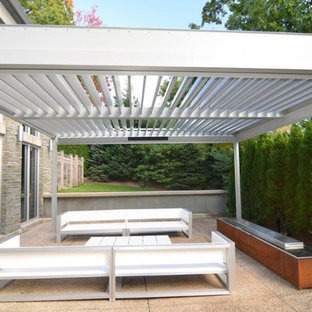 Esempio di un patio o portico minimal di medie dimensioni e dietro casa con graniglia di granito e una pergola