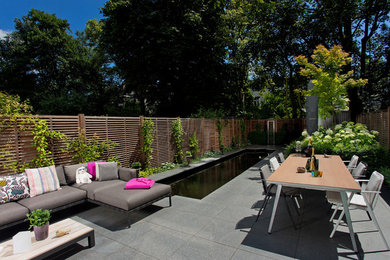 Design ideas for a medium sized contemporary back patio in Amsterdam with natural stone paving.