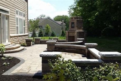 Diseño de patio tradicional renovado de tamaño medio sin cubierta en patio trasero con brasero y adoquines de hormigón