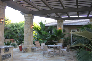 Design ideas for a large mediterranean back patio in Los Angeles with natural stone paving.