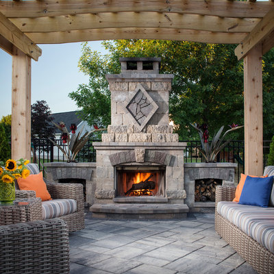 Inspiration for a mid-sized timeless backyard stone patio remodel in New York with a pergola and a fireplace